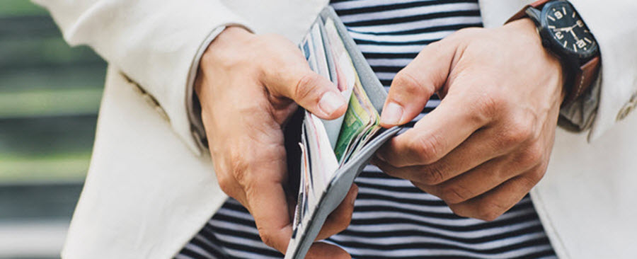 Close-up of a man opening his wallet. 