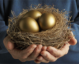 Hands holding a birds nest with golden eggs.