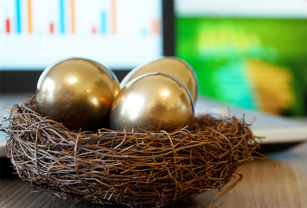 A nest of golden eggs sit in front of a laptop.