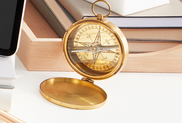 A compass is shown on an office desk.