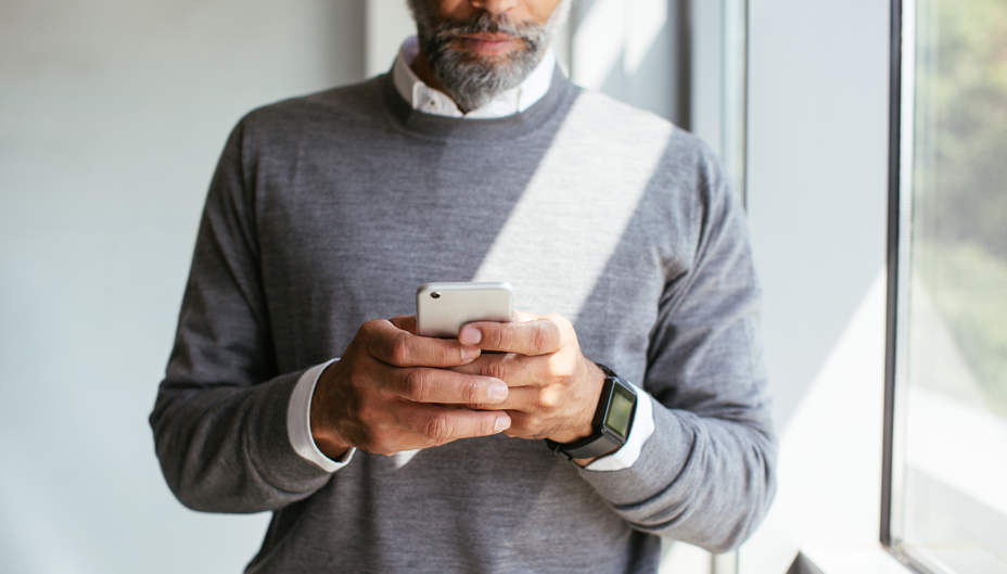 A man is looking down at his phone.