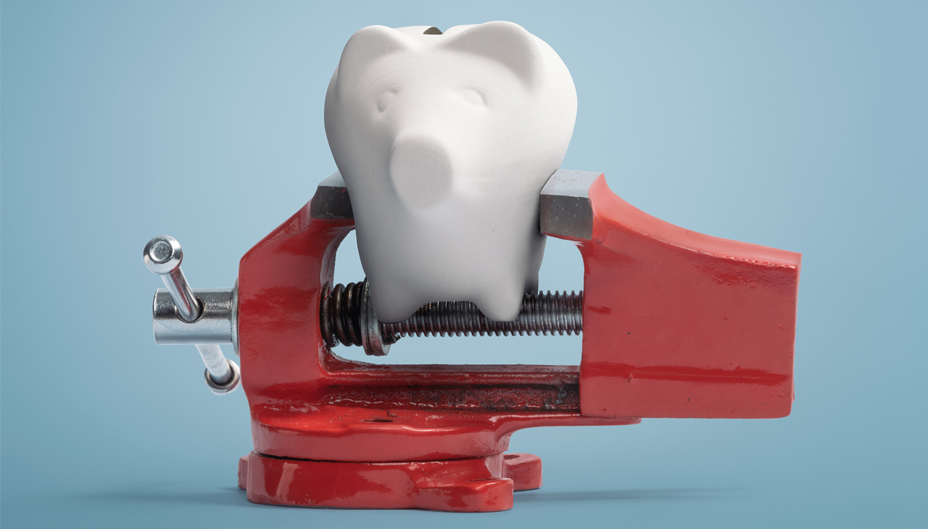 A vice grip squeezes a piggy bank.