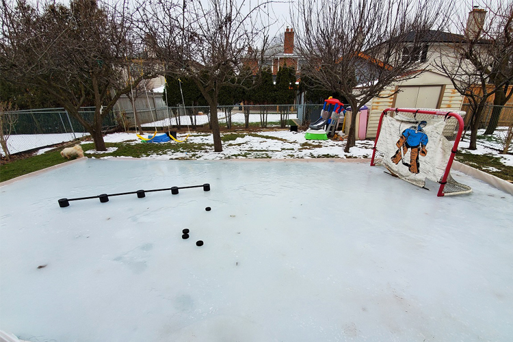 A hockey rink with pucks and a practice hockey net.