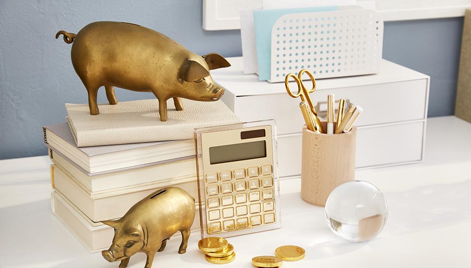 Des cochons dorés posés sur un bureau organisé.
